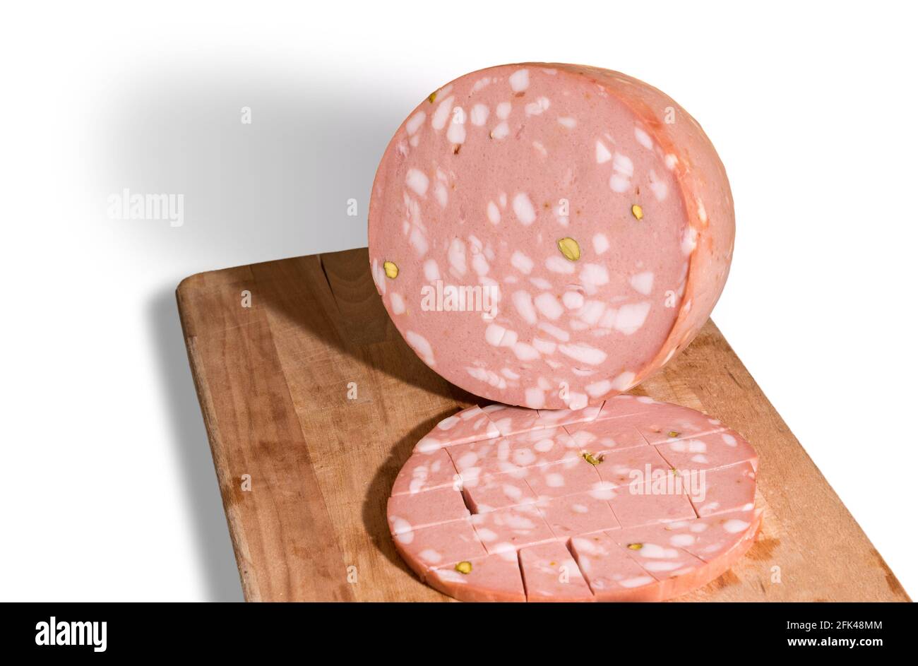 Mortadella Bologna con pistacchi su tagliere in legno isolato bianco Foto Stock