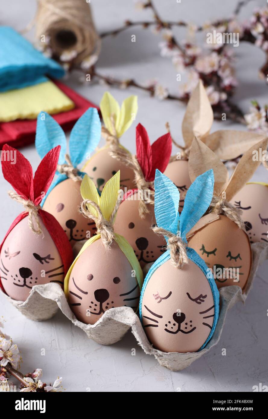 Coniglietti pasquali costituiti da uova con orecchie multicolore in carta  colorata o tovaglioli. Idea per decorare le uova di Pasqua. Formato  verticale Foto stock - Alamy