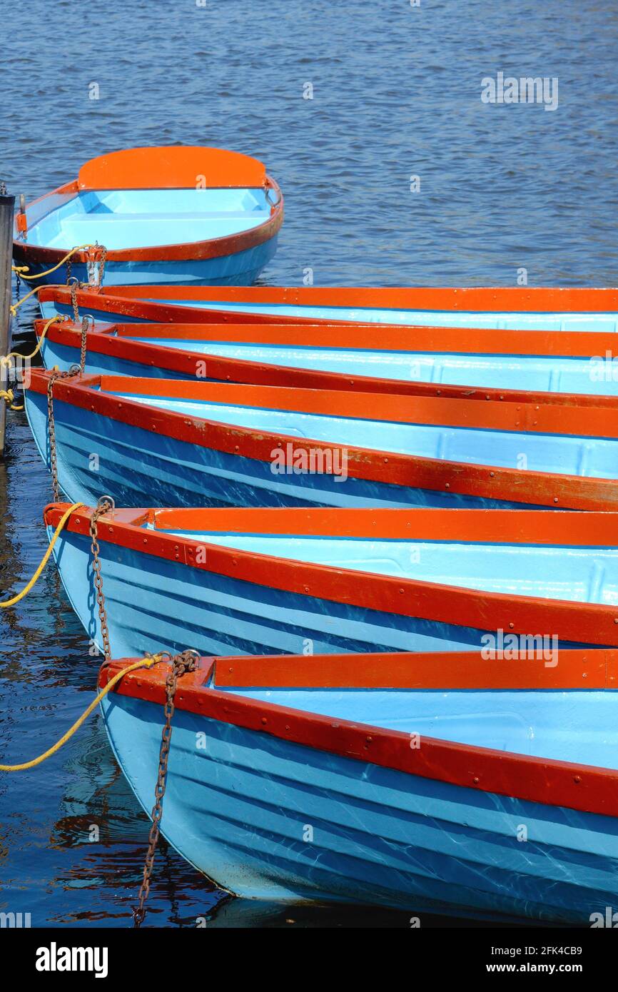Primo piano di remi in clinker verniciato blu e rosso barche che creano modelli astratti e forme Foto Stock