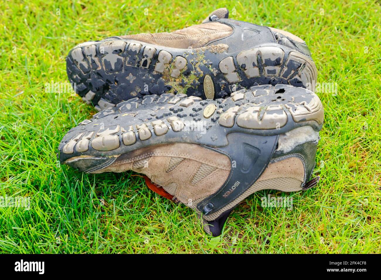 Usura fuori coppia di scarpe da trekking ben utilizzati, mostrando la mancanza di battistrada sulle suole. Foto Stock