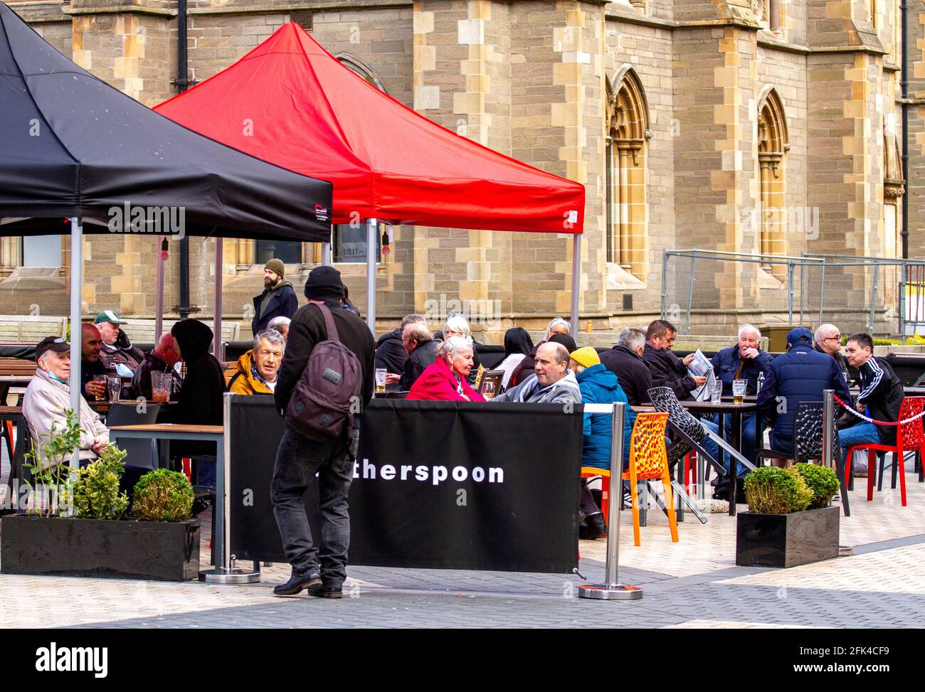 Dundee, Tayside, Scozia, Regno Unito. 28 aprile 2021. Regno Unito tempo: Freddo pomeriggio luminoso attraverso la Scozia nord-orientale con temperature che raggiungono i 9°C. I pub scozzesi hanno finalmente riaperto dopo mesi di rigide restrizioni di blocco del Covid-19. Il governo della Scozia ha permesso alle case pubbliche di tutto il paese di riaprire fino alle 22:00, purché abbiano giardini di birreria all'aperto. I residenti locali approfittano delle nuove norme di blocco e delle condizioni meteorologiche favorevoli per incontrare il pub Wetherspoon`s Counting House per gustare un drink nel centro di Dundee. Credit: Dundee Photographics/Alamy Live Foto Stock
