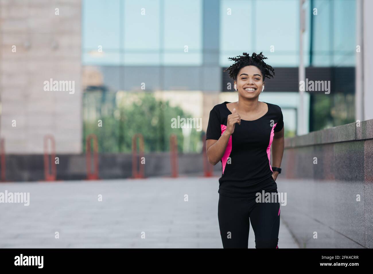 Atleta corridore, jogging su strada, fitness, allenamento in città e concetto di benessere Foto Stock