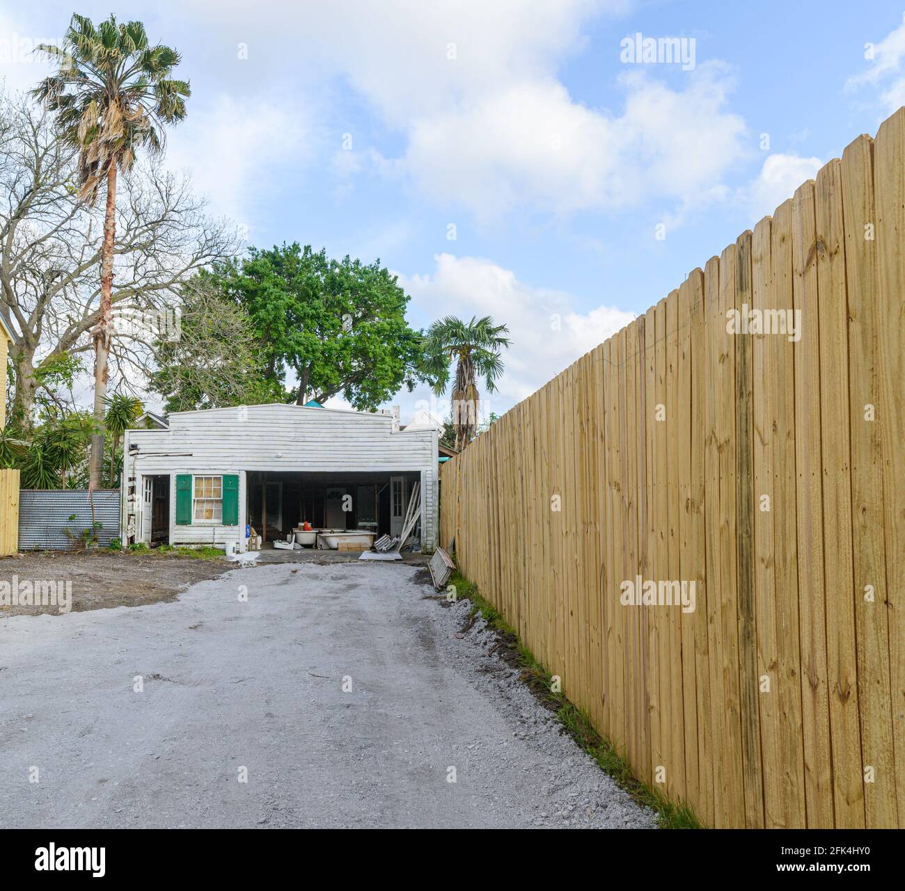 NEW ORLEANS, LA, Stati Uniti d'America - 19 APRILE 2021: Vialetto per il vecchio picchiaduro garage e nuovo recinto di legno Foto Stock