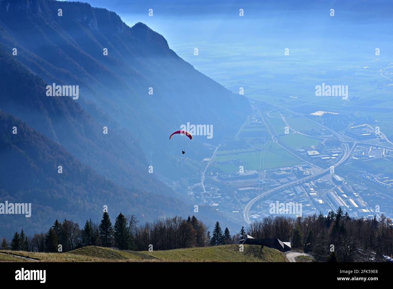 Un parapendio che si decollerà su una valle con un drammatico sfondo di montagne Foto Stock