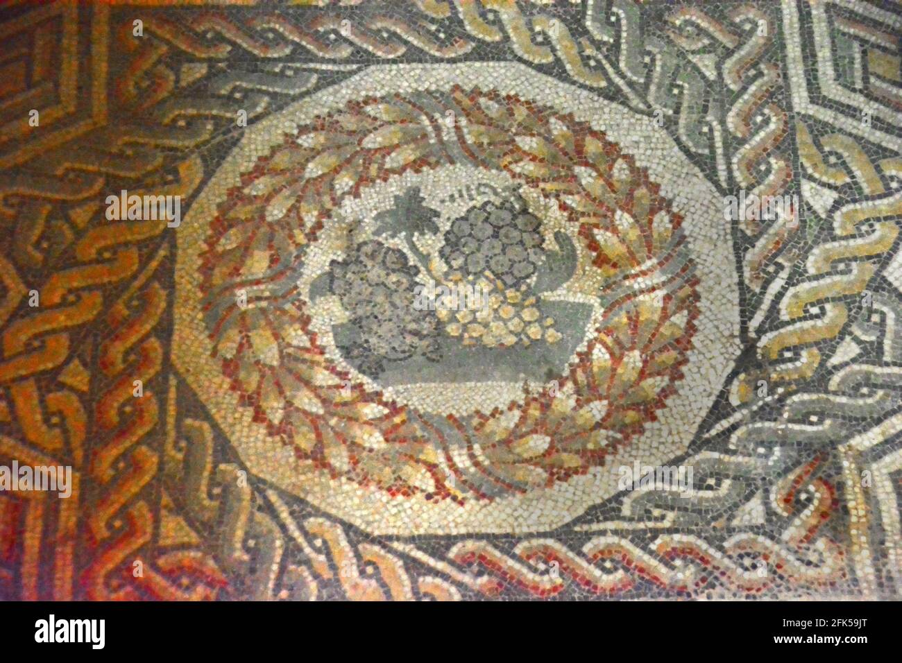 Antico pavimento a mosaico romano con immagine di uve rosse e bianche. Nella Villa Romana del Casale, in Sicilia, patrimonio dell'umanità dell'UNESCO, i mosaici antichi romani Foto Stock