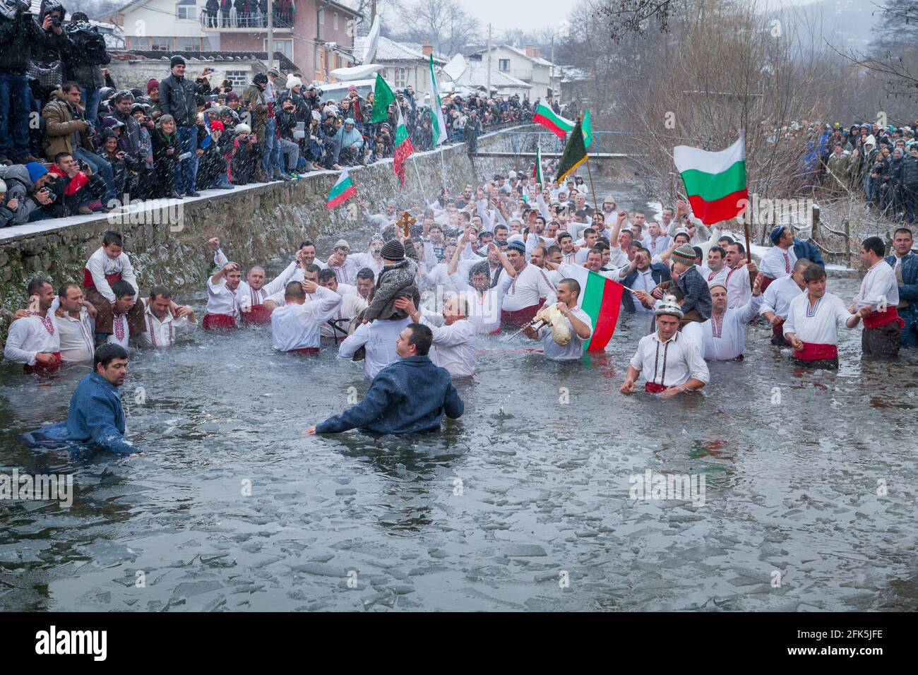 Tradizioni Epifania - giorno della Giordania. Croce trascinata, e gli uomini giocano a ballare nelle acque ghiacciate del fiume Tundzha il 6 gennaio 2015, Kalofer, Bulgaria Foto Stock
