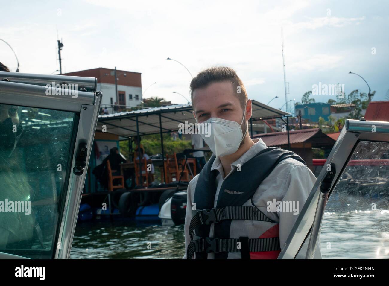Uomo biondo caucasico guardando la macchina fotografica in una barca Nel serbatoio dell'acqua Foto Stock