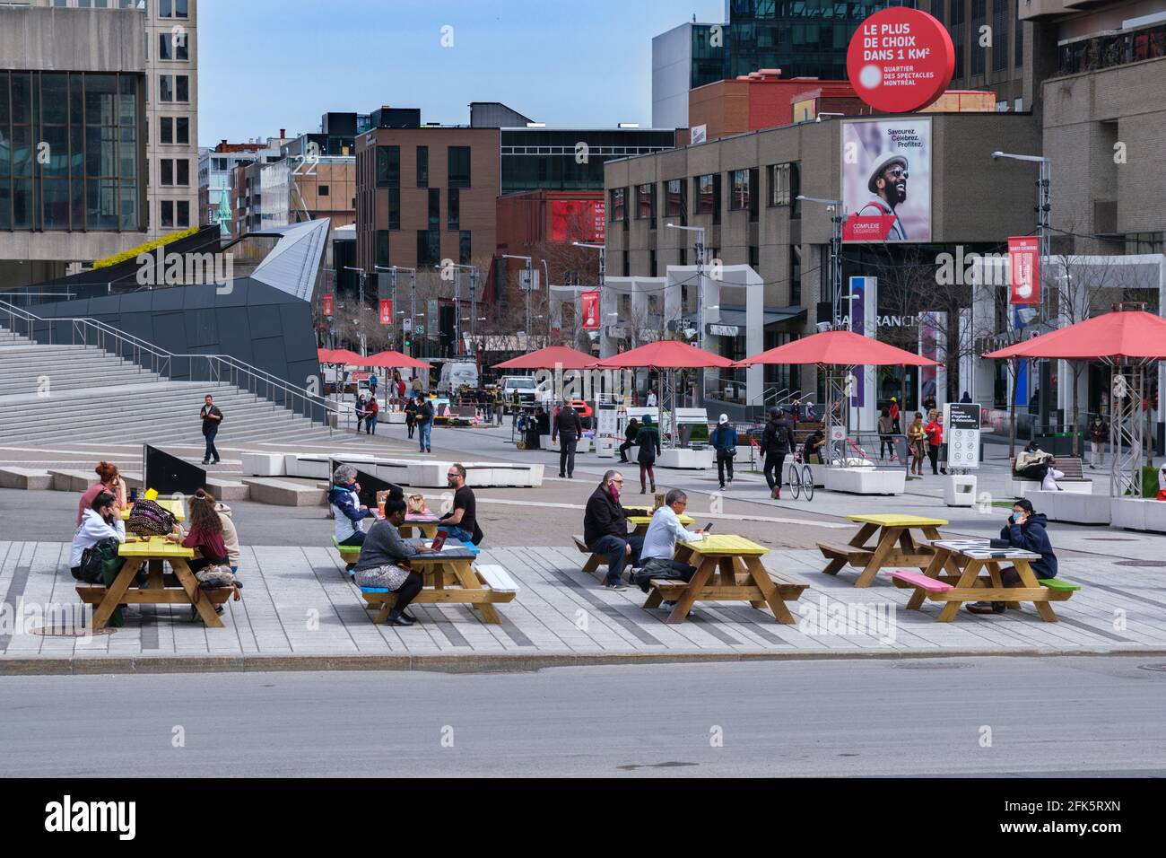 Montreal, CA - 28 aprile 2021: Persone sedute a tavoli da picnic su Ste Catherine Street nel centro di Montreal. Foto Stock