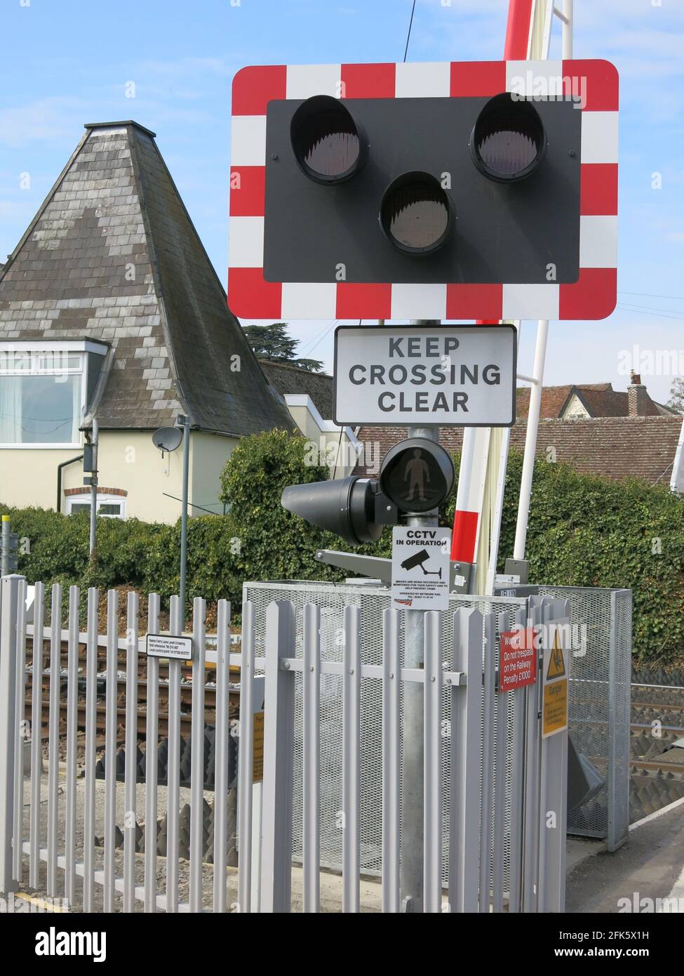 Uno degli incroci di livello a Woodbridge, Suffolk con i semafori e le barriere per gli utenti della strada, 'Keep Crossing Clear'. Foto Stock