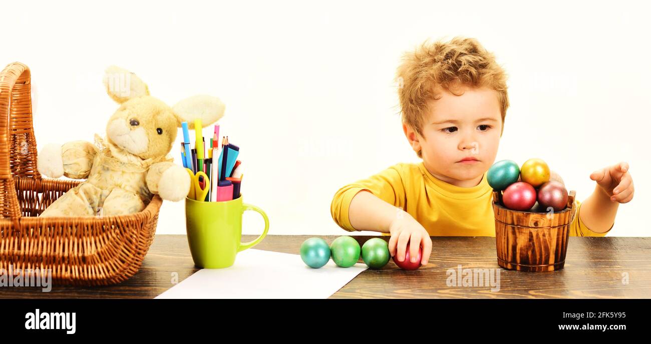 Piccolo bambino che dipinge le uova di Pasqua. Creatività pasquale per bambini. Ragazzo decorare uovo di Pasqua. Foto Stock