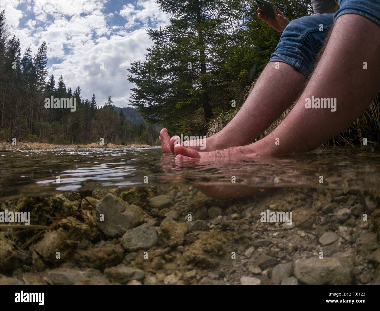 Piedi rinfrescanti escursionisti nel freddo fiume di montagna Foto Stock