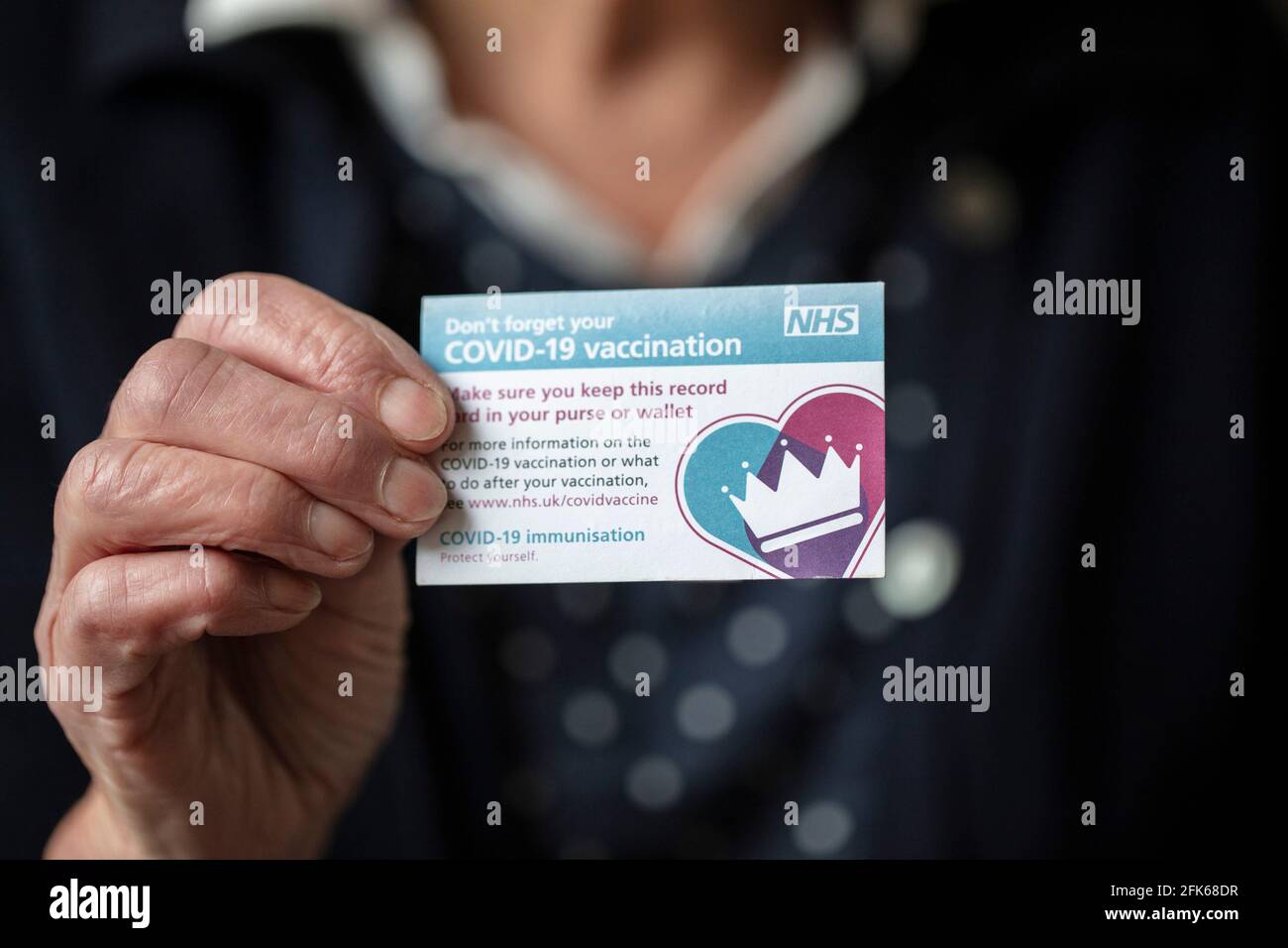 LONDRA, REGNO UNITO - APRILE 2021. Una persona in possesso della tessera NHS Covid-19 per la registrazione delle vaccinazioni Foto Stock