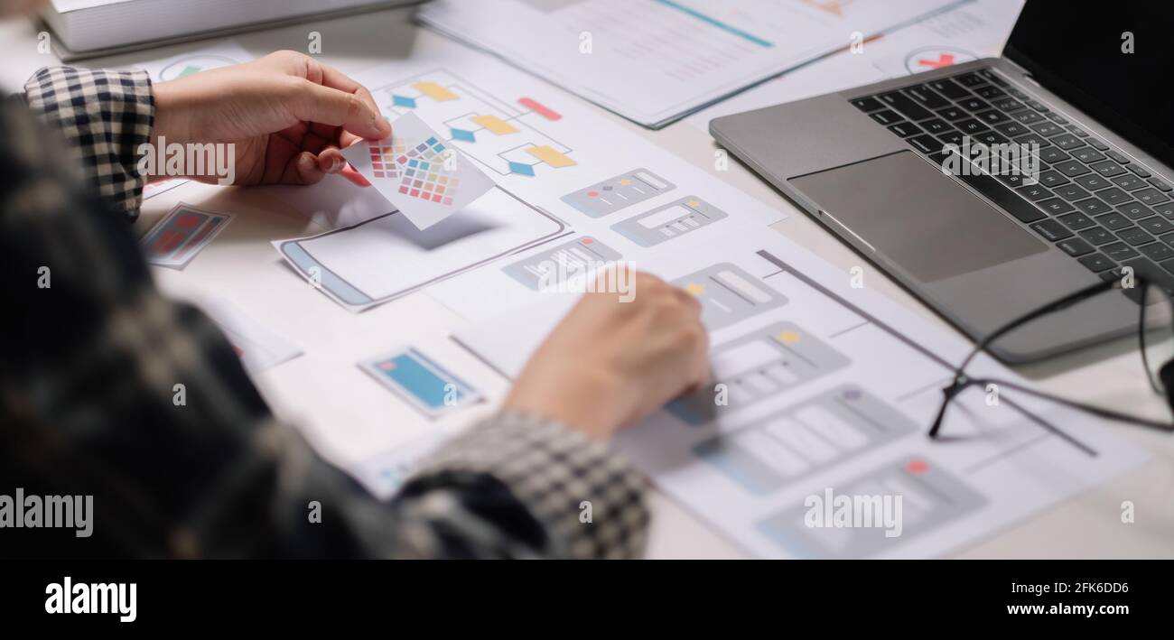 Closeup di sviluppatori ux femminili e ui designer su mobile Interfaccia dell'app per telefono nel salotto di casa.sviluppo digitale creativo concetto di agenzia Foto Stock