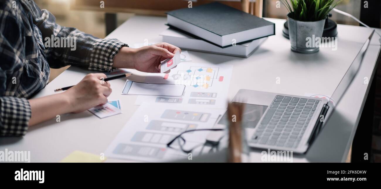 Closeup di sviluppatori ux femminili e ui designer su mobile Interfaccia dell'app per telefono nel salotto di casa.sviluppo digitale creativo concetto di agenzia Foto Stock
