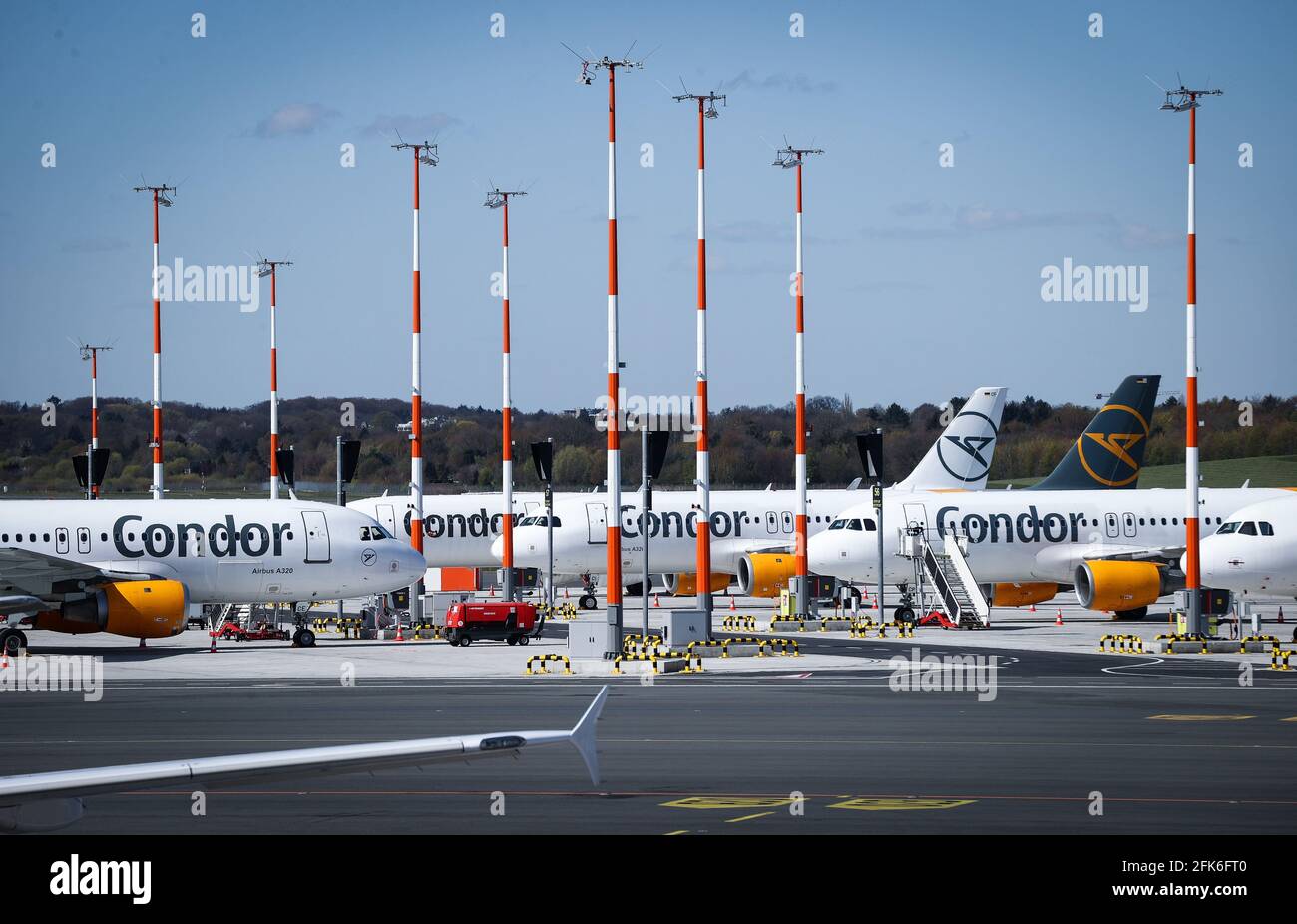 Amburgo, Germania. 27 Apr 2021. Aereo della compagnia aerea Condor parcheggia sul grembiule all'aeroporto di Amburgo. Solo circa il dieci per cento dei passeggeri abituali attualmente a bordo di un aereo nella città anseatica. L'aeroporto è stato certificato dall'associazione internazionale Aereoporti Council International per quanto riguarda lo standard delle sue misure di protezione e igiene corona. (Al dpa 'Aeroporto di Amburgo: Terminal vuoto, certificato Corona e routine') credito: Christian Charisius/dpa/Alamy Live News Foto Stock