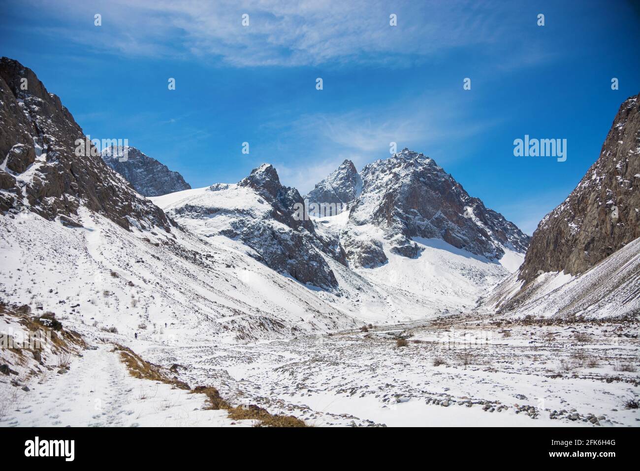 Idilliaco paesaggio invernale con sentieri escursionistici in montagna. Rocce, neve e pietre in vista valle di montagna. Panorama di montagna. Foto Stock