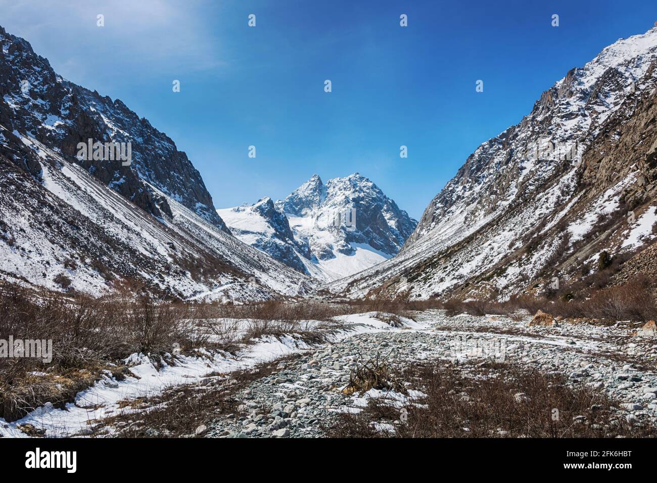Idilliaco paesaggio invernale con sentieri escursionistici in montagna. Rocce, neve e pietre in vista valle di montagna. Panorama di montagna. Foto Stock