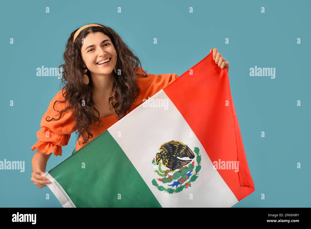 Giovane bella donna con bandiera messicana su sfondo a colori Foto Stock