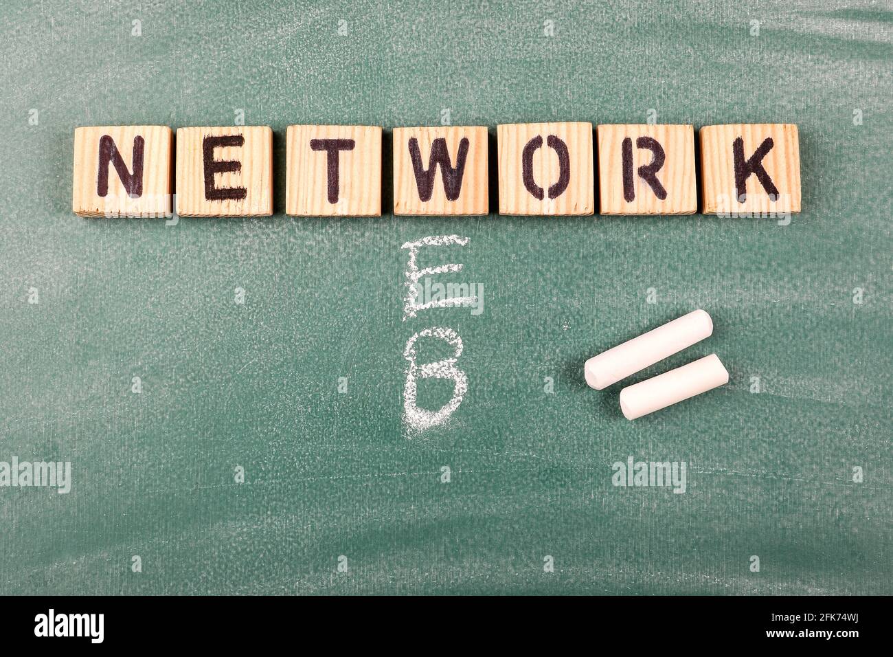 Concetto di rete e Web. Lettere alfabetiche in legno su una tavola di gesso verde. Foto Stock