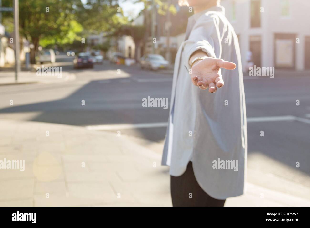 donna che torna indietro con mano fuori Foto Stock