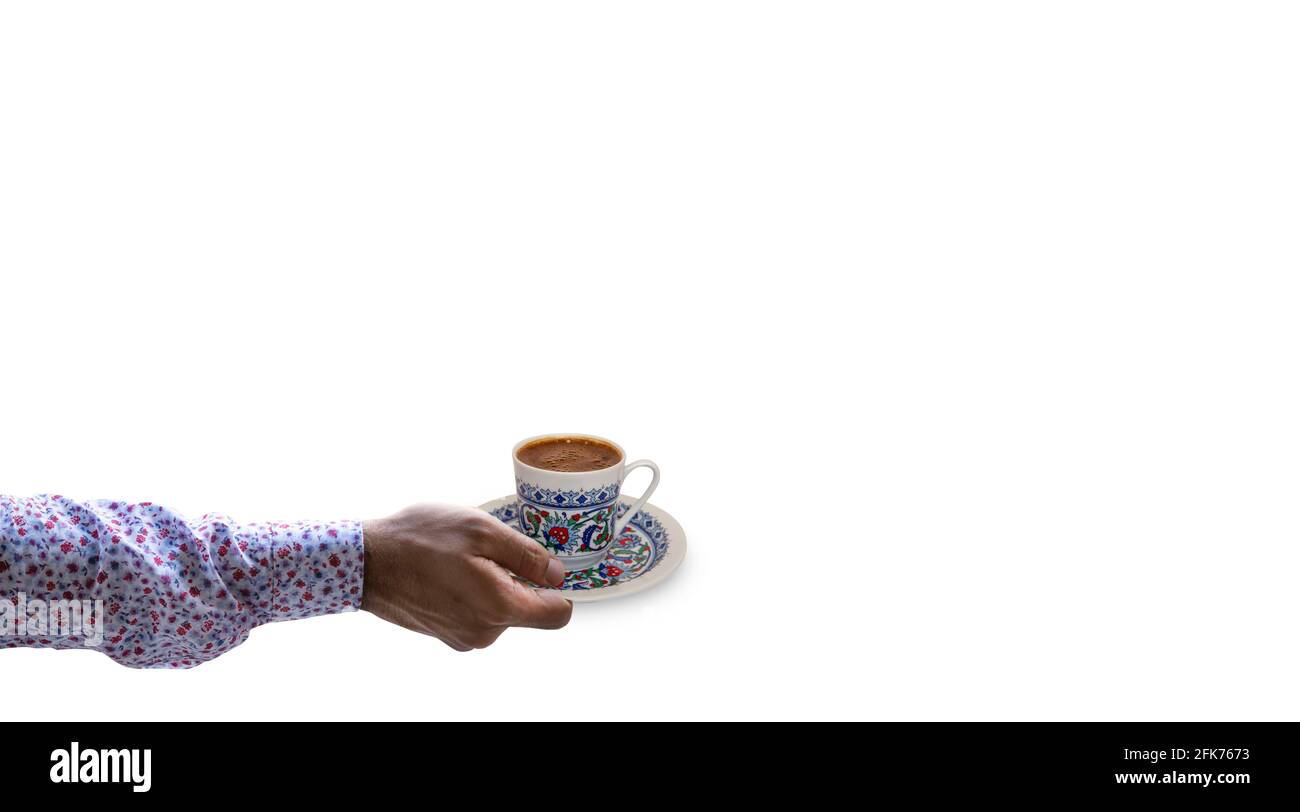 Mano dell'uomo che tiene la tazza di caffè turca su sfondo isolato Foto Stock