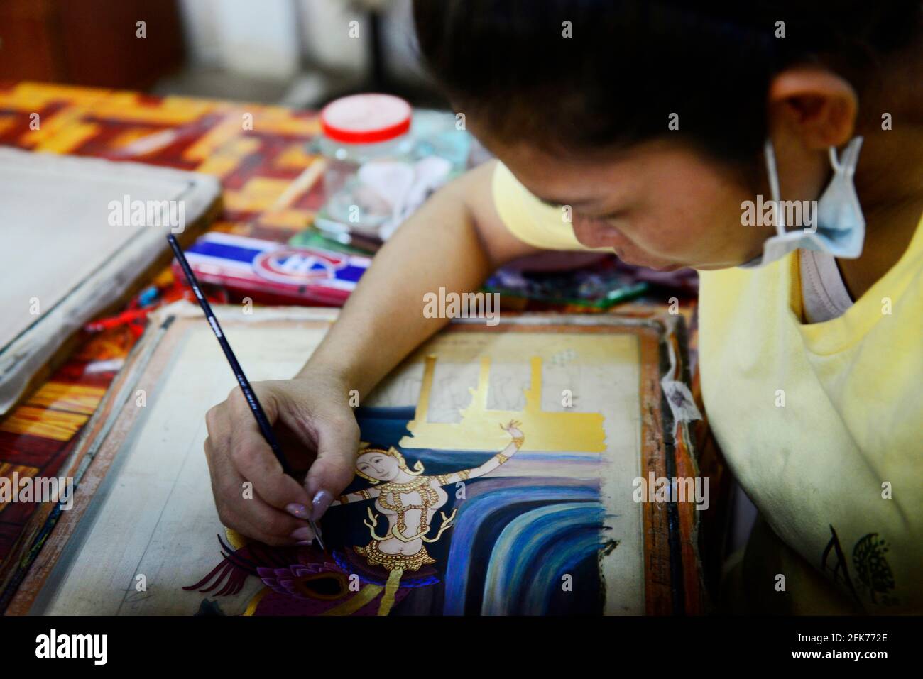 Un pittore cambogiano che lavora sulla sua pittura tradizionale Khmer in laboratorio Artisans d'Angkor a Siem Reap, Cambogia. Foto Stock