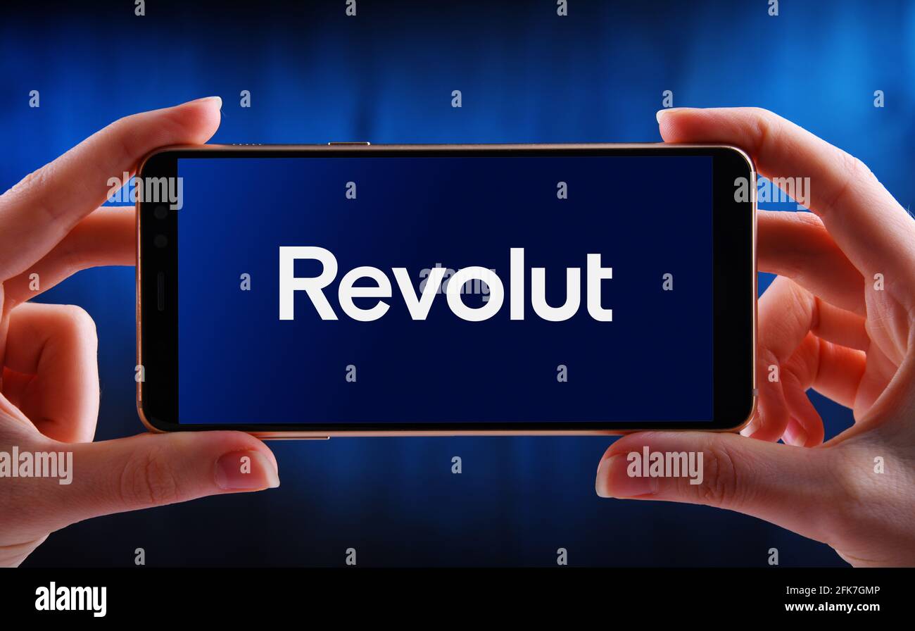 POZNAN, POL - Apr 15, 2021: Smartphone con mani in mano che mostra il logo di Revolut, una società di tecnologia finanziaria con sede a Londra, Inghilterra, che Foto Stock