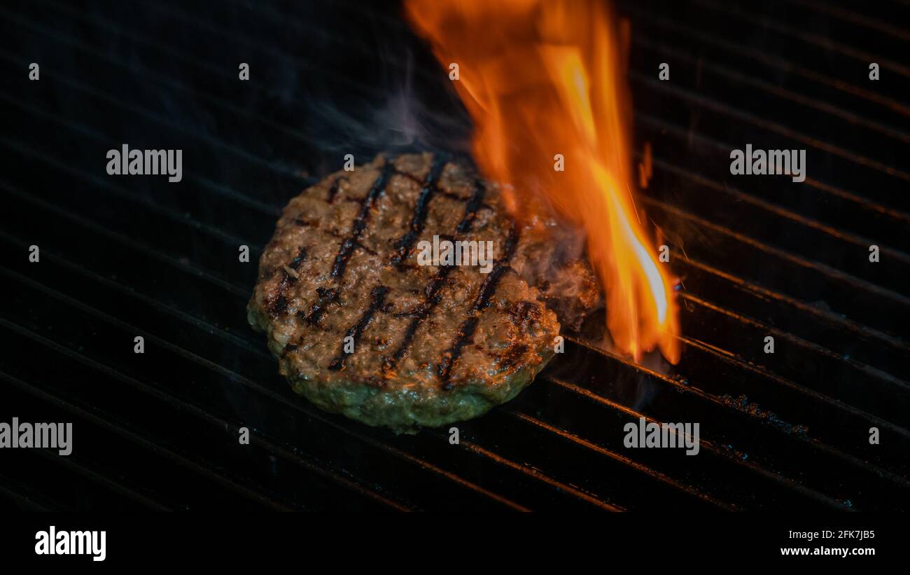 cottura hamburger patatine frittate sulla griglia calda con fiamme.  Preparazione Burger Foto stock - Alamy