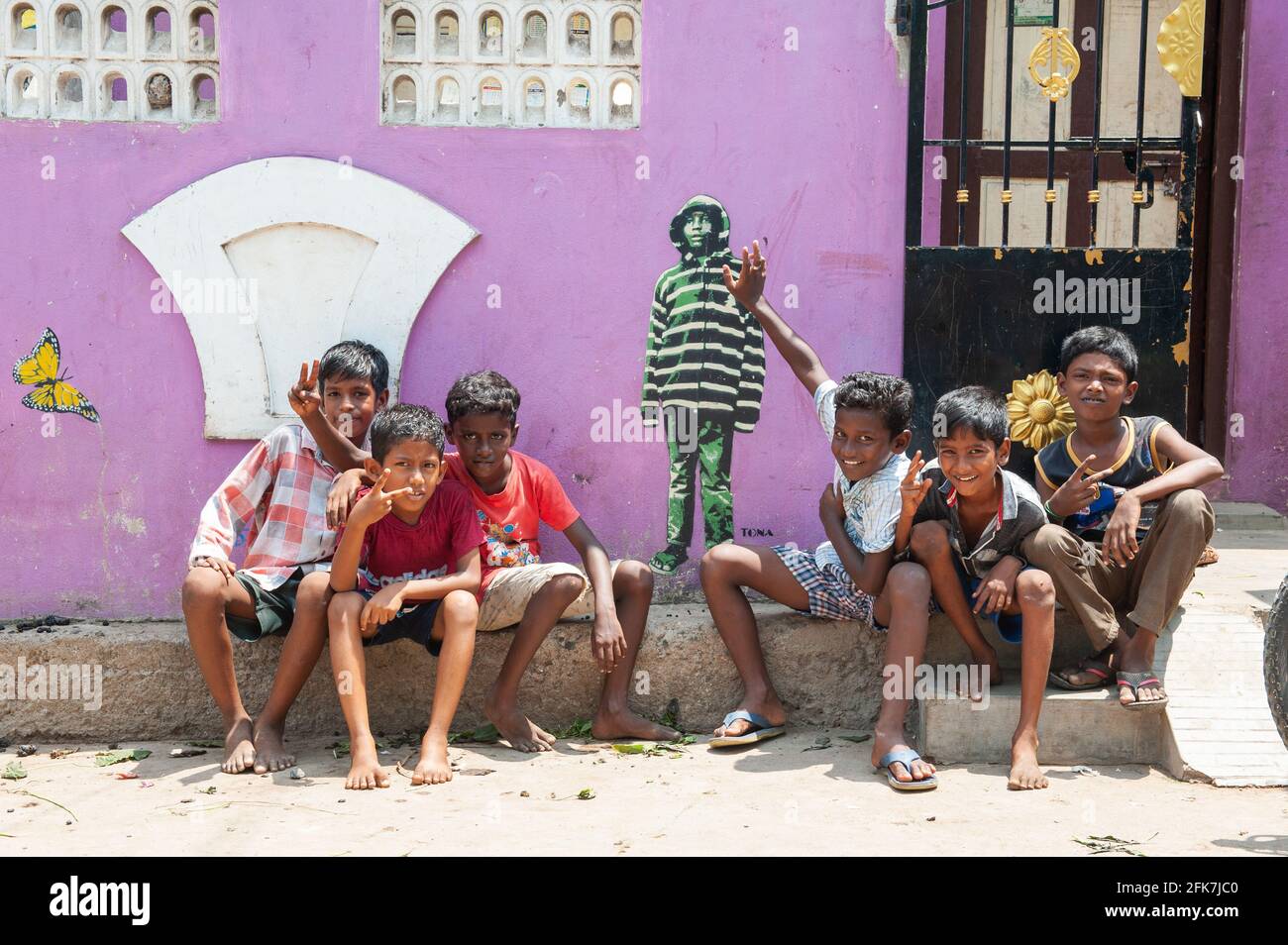 PONDICHERRY, INDIA - Aprile 2021: Bambini che posano accanto ad un graffito realizzato dall'artista di strada tedesco Tona. Foto Stock