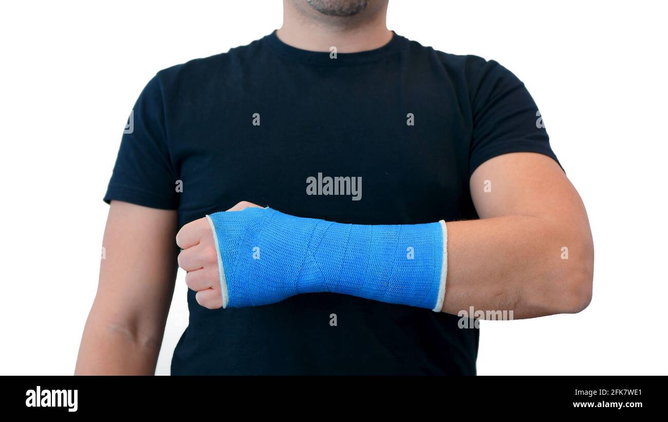 L'uomo irriconoscibile in una T-shirt nera mostra avvolto a mano in un calco di gesso in fibra di vetro su uno sfondo bianco. Polso rotto in moderno bendaggio blu impermeabile Foto Stock