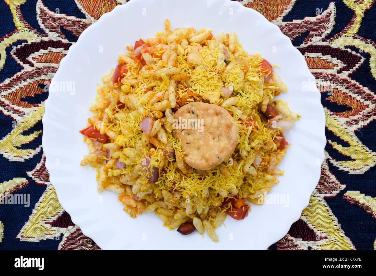 Bhelpuri, popolare cibo di strada indiano a base di riso soffiato e SEV. Spuntini indiani serviti in un piatto sul tavolo. Speciale oggetto famoso chaat da i Foto Stock