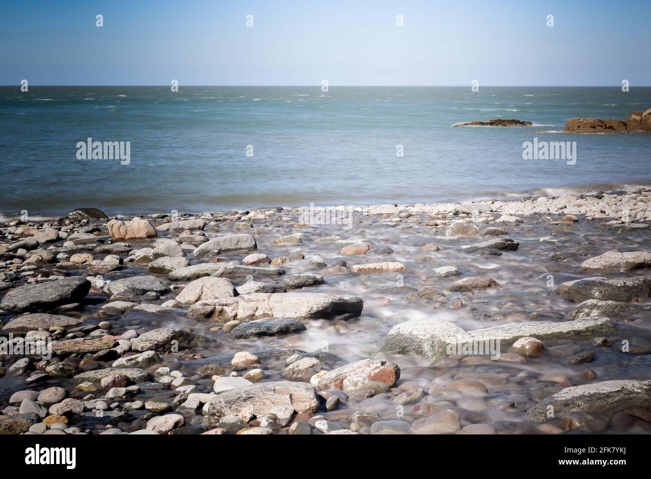 Spiaggia con ciottoli e onde nebbie Foto Stock