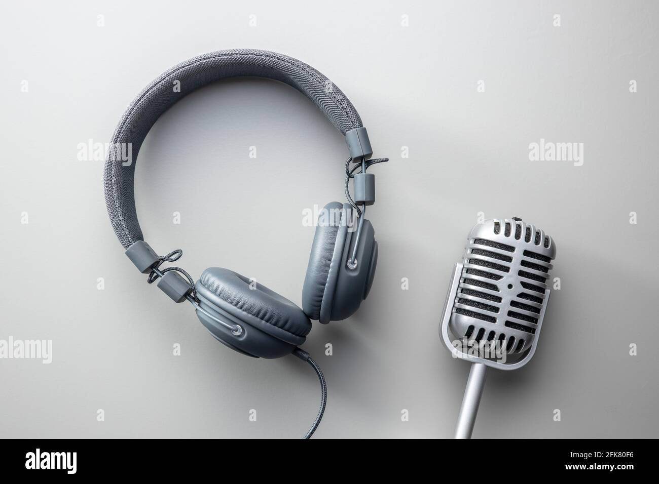 Microfono e cuffie vintage su sfondo grigio. Vista dall'alto. Foto Stock