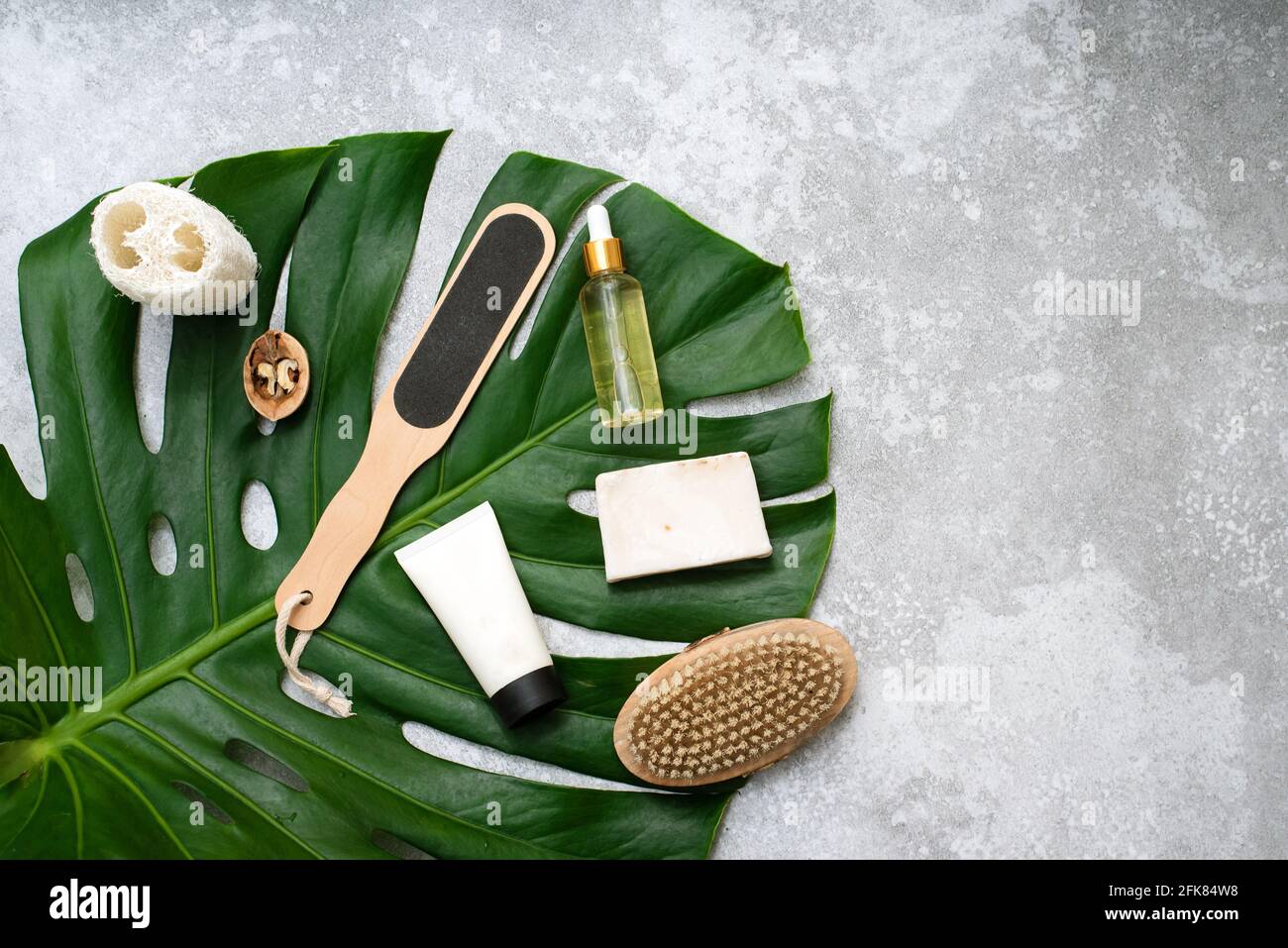 Composizione Spa con prodotti per la cura del corpo e piante su sfondo grigio. Vista dall'alto. Foto Stock