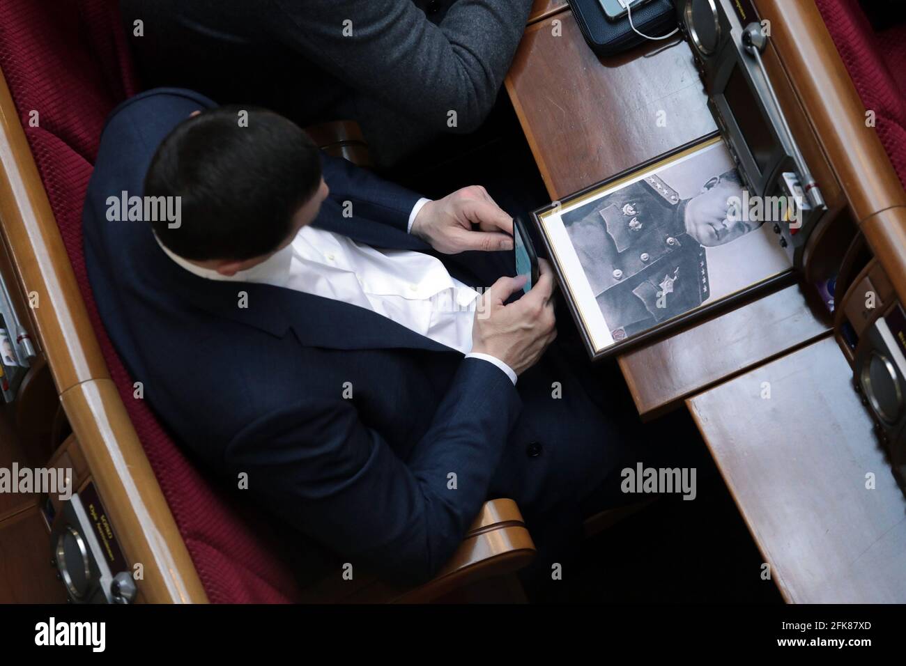 KIEV, UCRAINA - 29 APRILE 2021 - un deputato siede prima di una foto di un veterano della seconda guerra mondiale durante una seduta regolare del parlamento ucraino, Kiev, capitale del Regno Unito Foto Stock