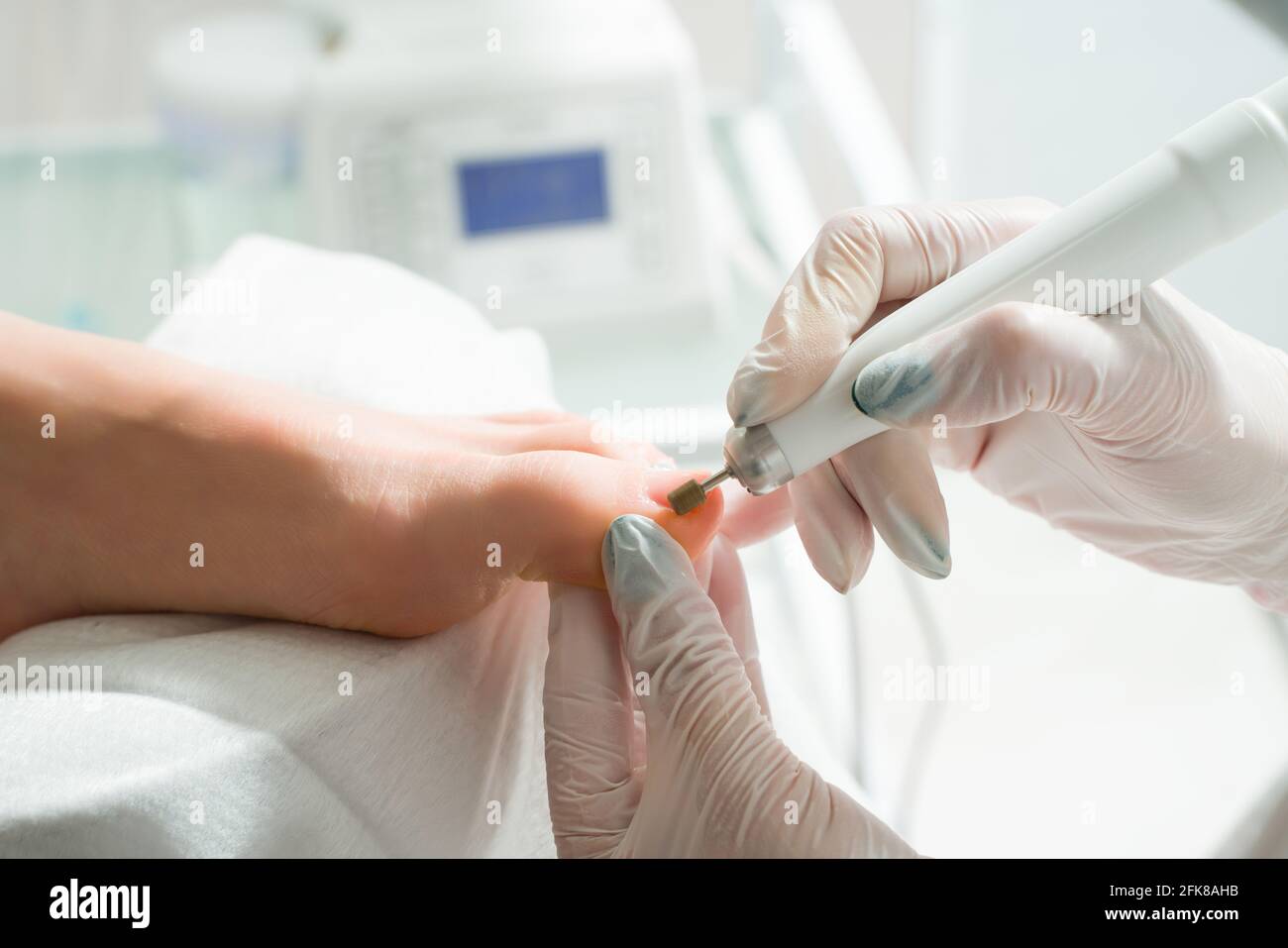 Un medico di podiatrist che si prende cura delle toenails di una donna. Procedure cosmetiche dei piedi Foto Stock