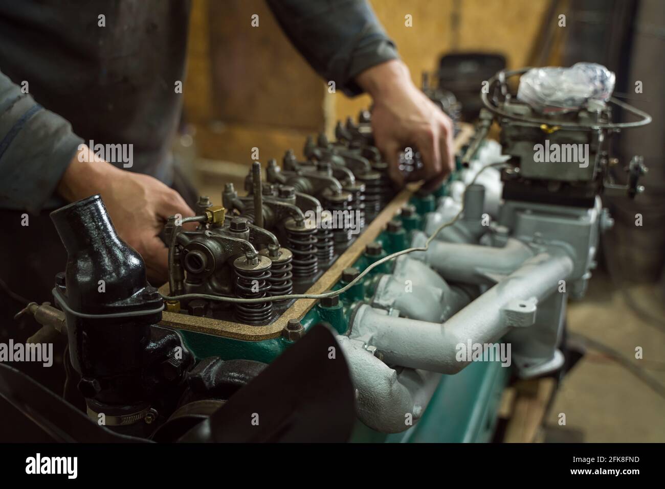 Meccanico dell'automobile che ripara un motore. Meccanico che lavora sul motore dell'automobile. Officina meccanica. Foto Stock