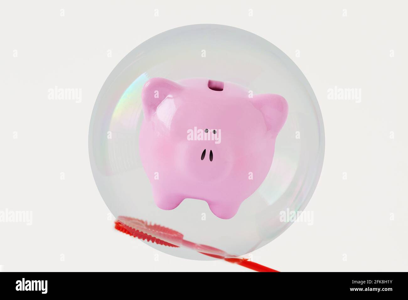Banco di piggy in bolla di sapone su sfondo bianco - concetto del risparmio e dell'insicurezza economica Foto Stock