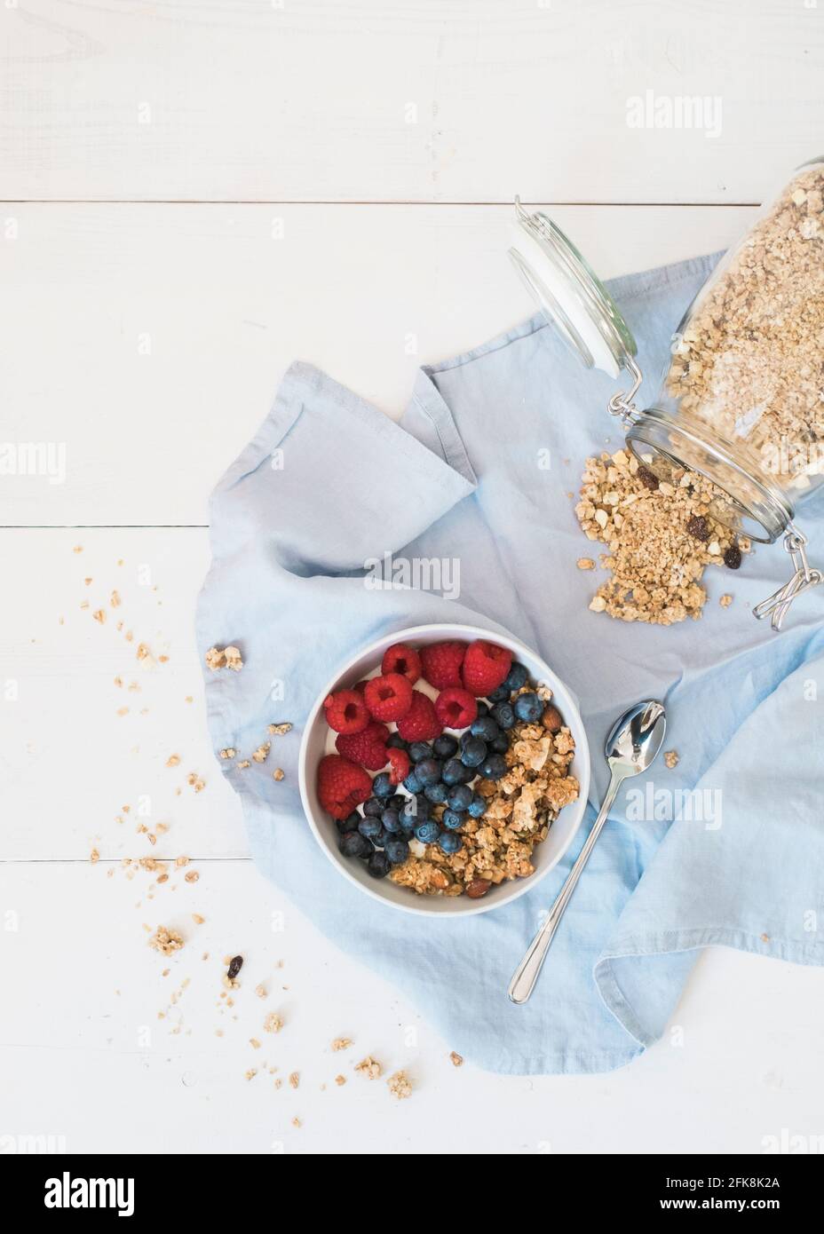 Yogurt con muesli, mirtilli e lamponi. Fotografia di cibo pulita e luminosa Foto Stock