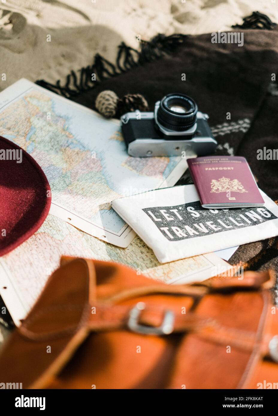 Ancora vita di cose da viaggio. Un passaporto, un cappello, una macchina fotografica e una mappa su una spiaggia Foto Stock