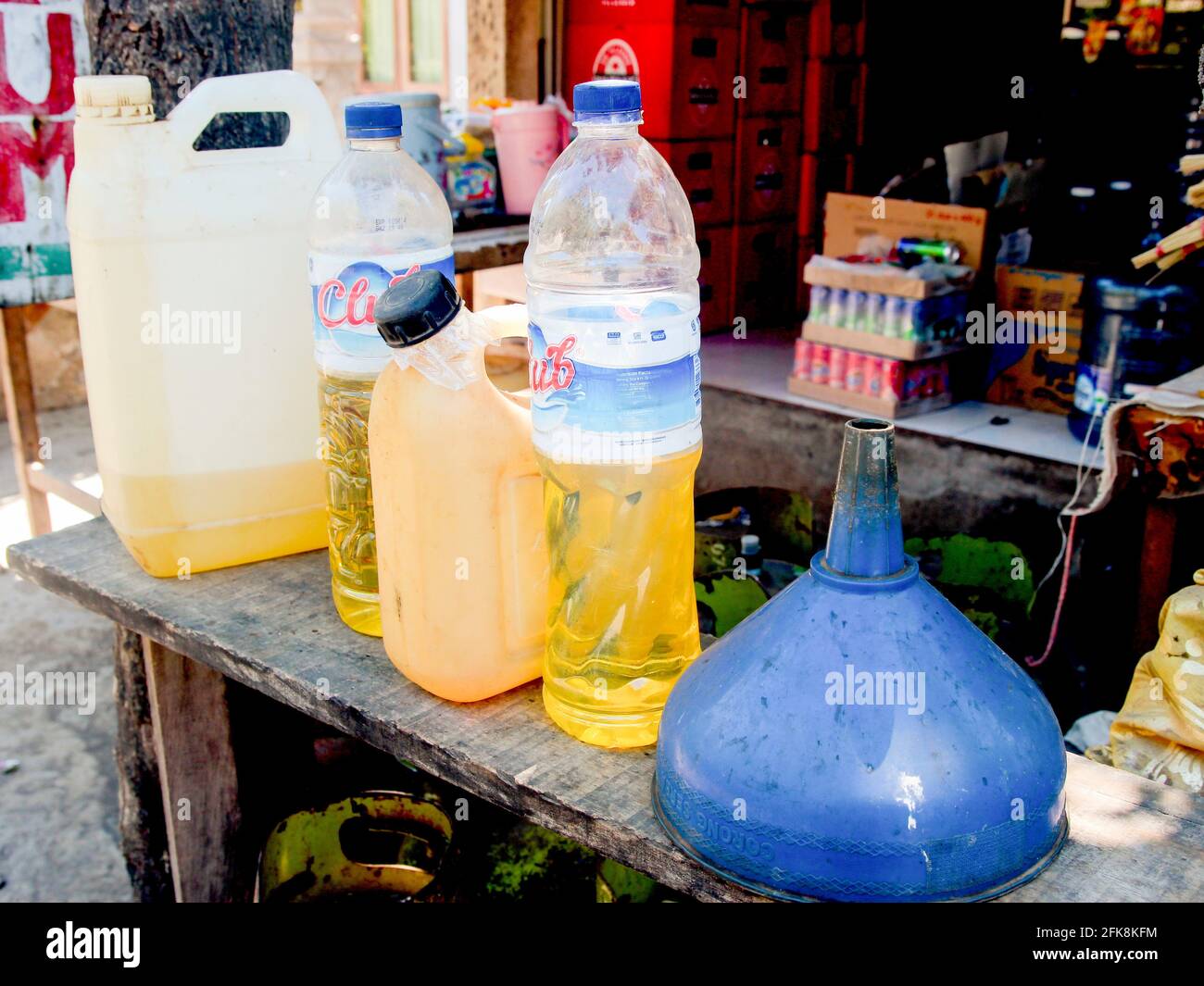 Dettaglio di una stalla con litri di benzina per auto, scooter. Il gas viene misurato in bottiglie d'acqua in plastica riutilizzate. A Bali, Indonesia. Foto Stock