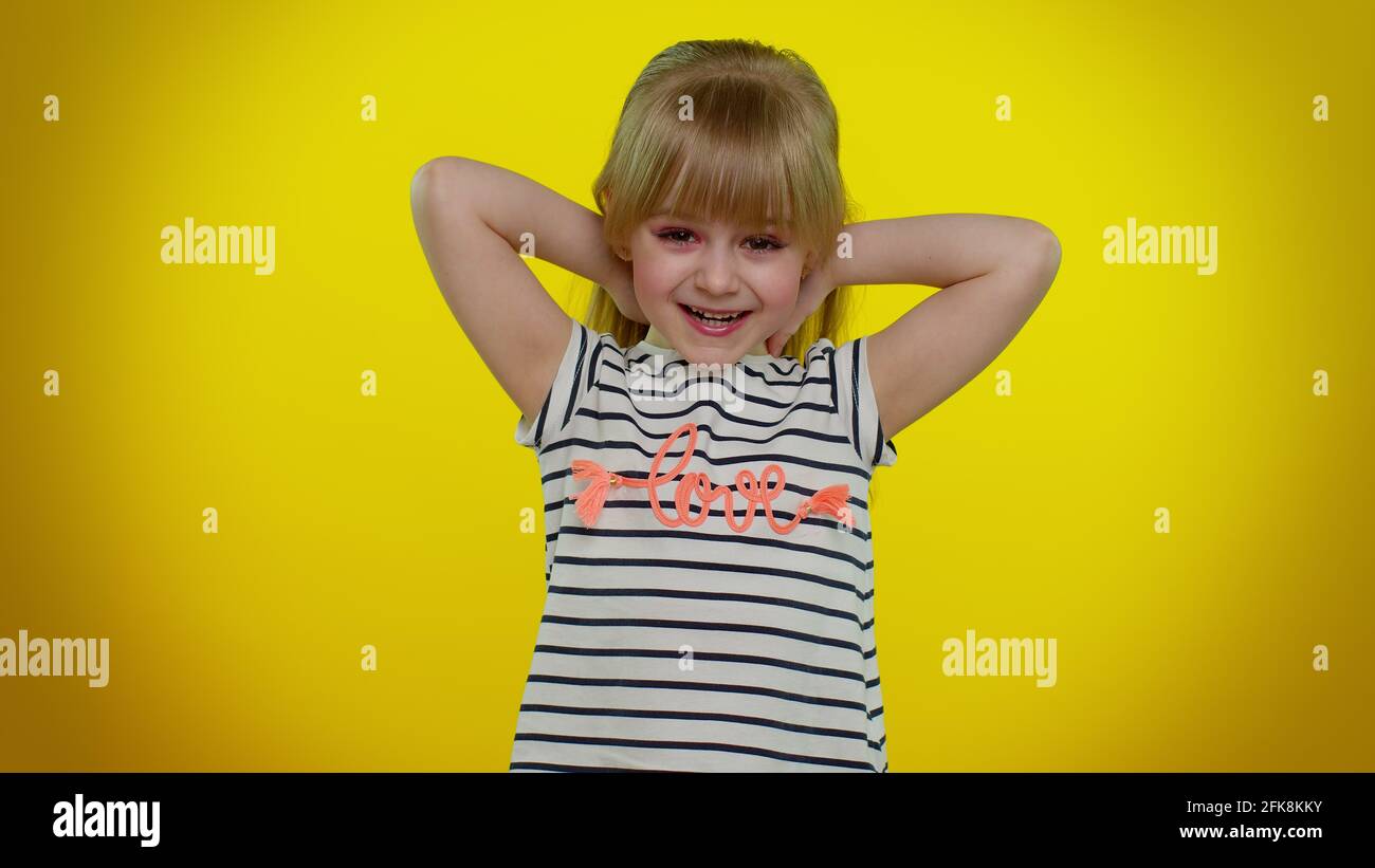 Bambina bambina piccola bionda festeggia la vittoria di successo, gioisce facendo gesto vincitore dire Sì, ballando Foto Stock