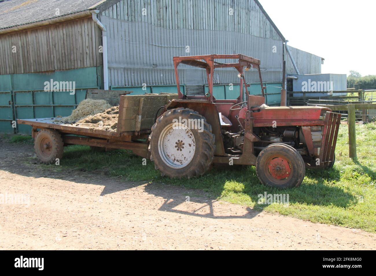 Un trattore arrugginito d'epoca in un'azienda agricola attiva. Foto Stock