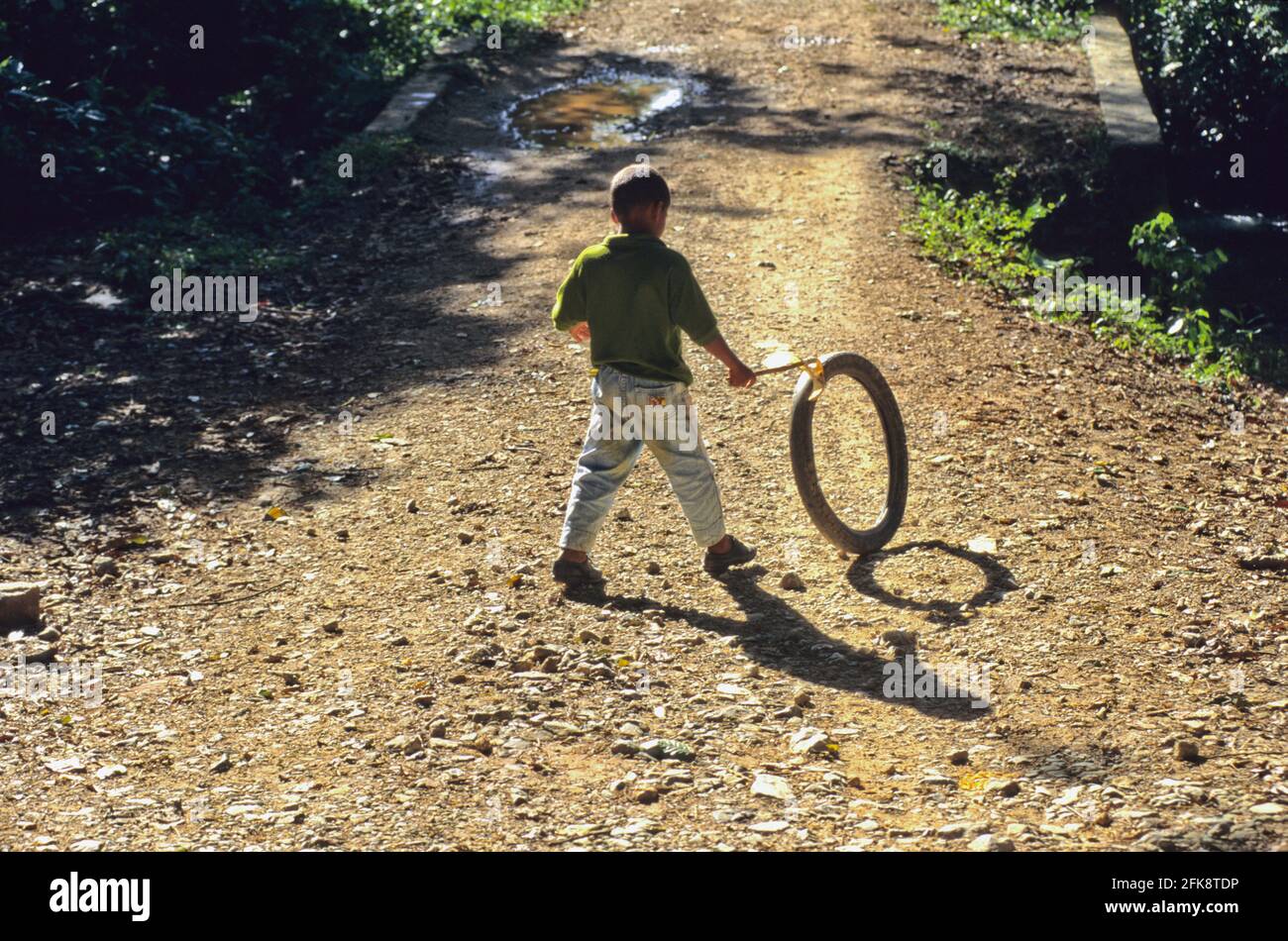 Dominikanische Republik, mit Mopedreifen spielender Junge, auf Samana Foto Stock
