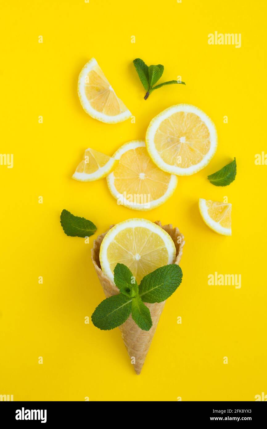 Cono gelato con limone tritato e menta su sfondo giallo. Primo piano. Foto Stock