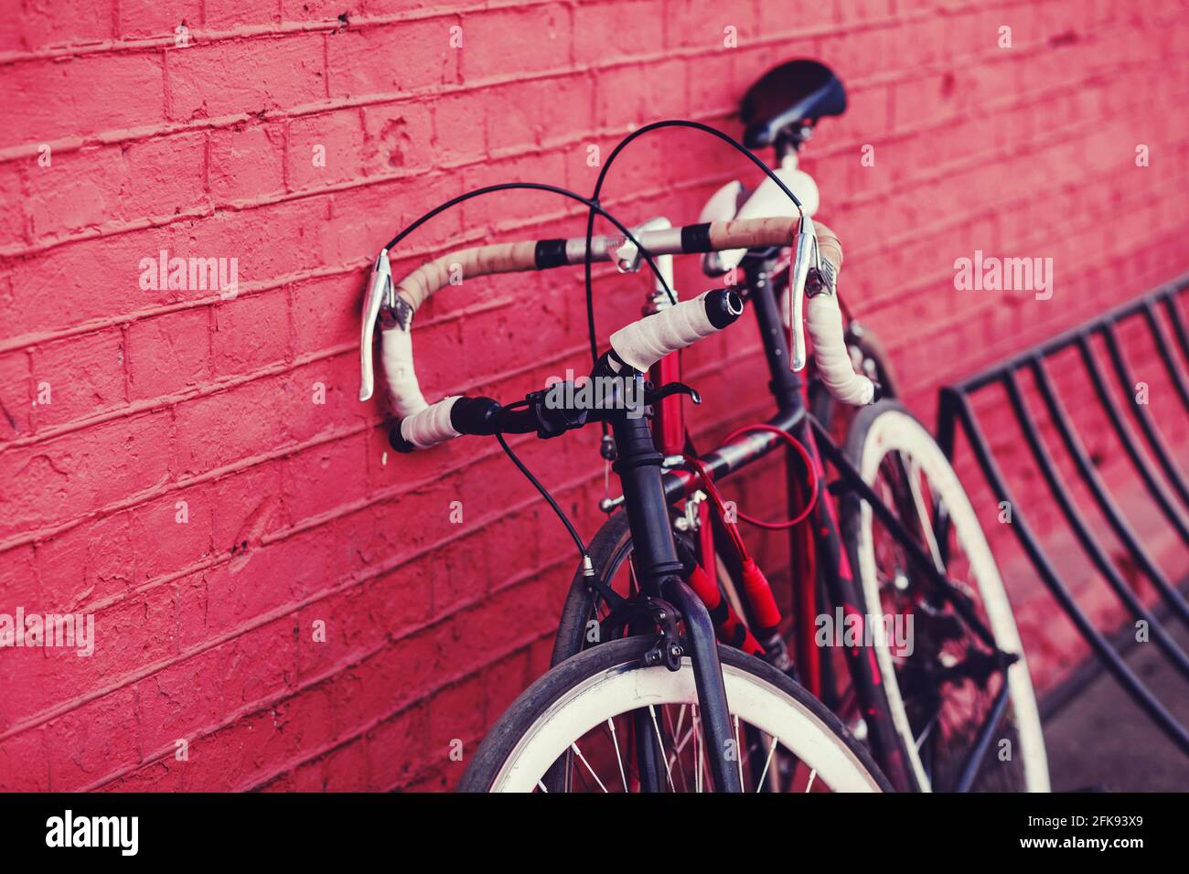 due parcheggi per biciclette d'epoca contro le mura colorate della città Foto Stock