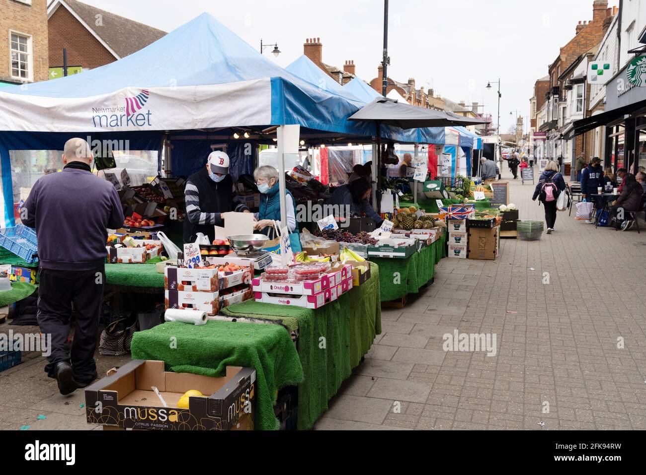 Street Market UK; il mercato due volte alla settimana con bancarelle e negozi di persone, High Street, Newmarket Town Center, Newmarket, Suffolk, REGNO UNITO Foto Stock