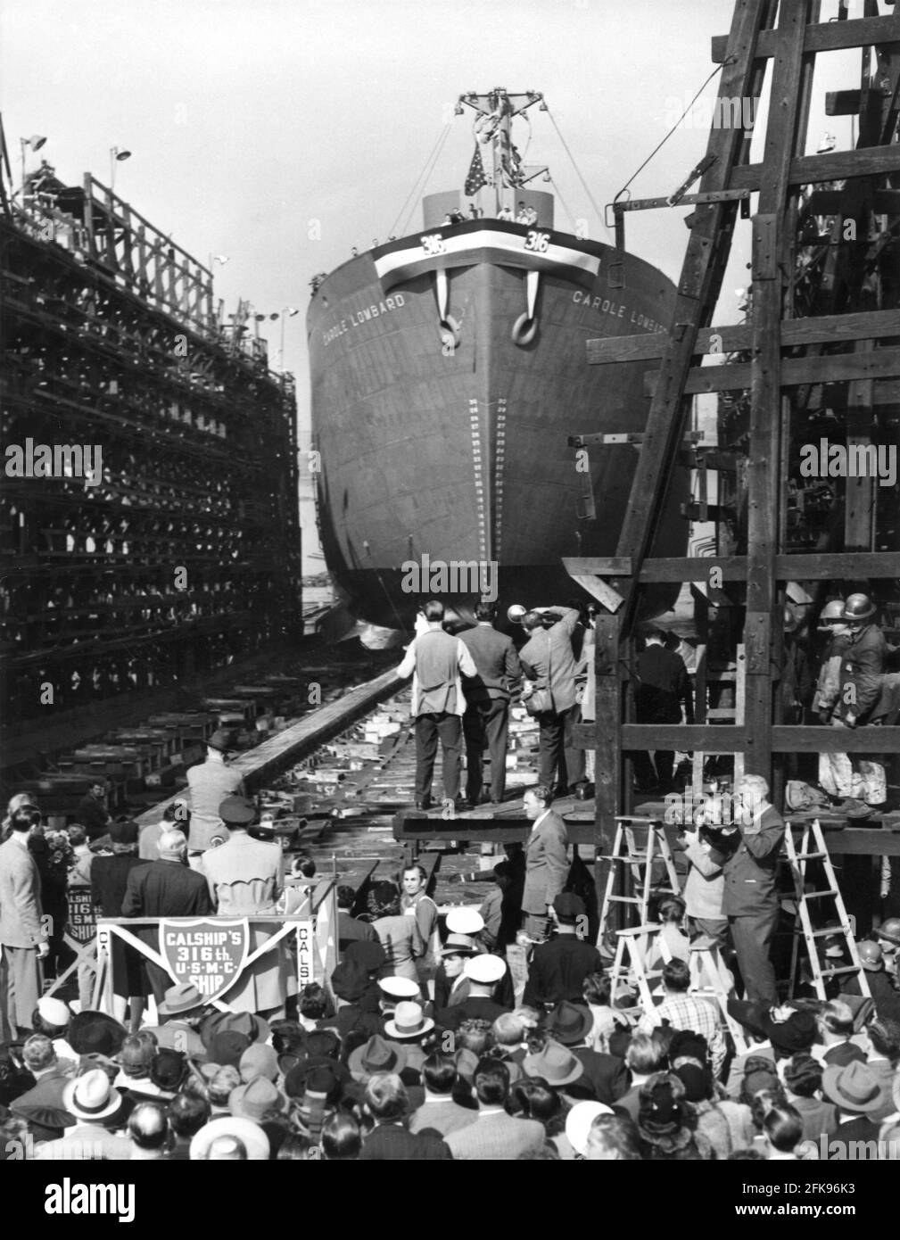 IRENE DUNNE LOUIS B. MAYER e Captain CLARK GABLE delle forze Armate degli Stati Uniti (tutte le spalle alla macchina fotografica sulla piattaforma) alla cerimonia di battesimo per la nave della libertà U.S.S. CAROLE LOMBARD sabato 15 gennaio 1944 presso il Terminal Island Docks tra il Porto di Los Angeles e il Porto di Long Beach, California Foto Stock