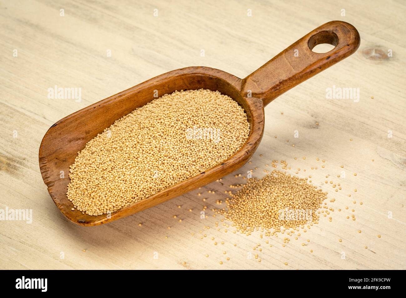 chicco di amaranto senza glutine su una paletta rustica di legno contro legno di fondo afflitto Foto Stock