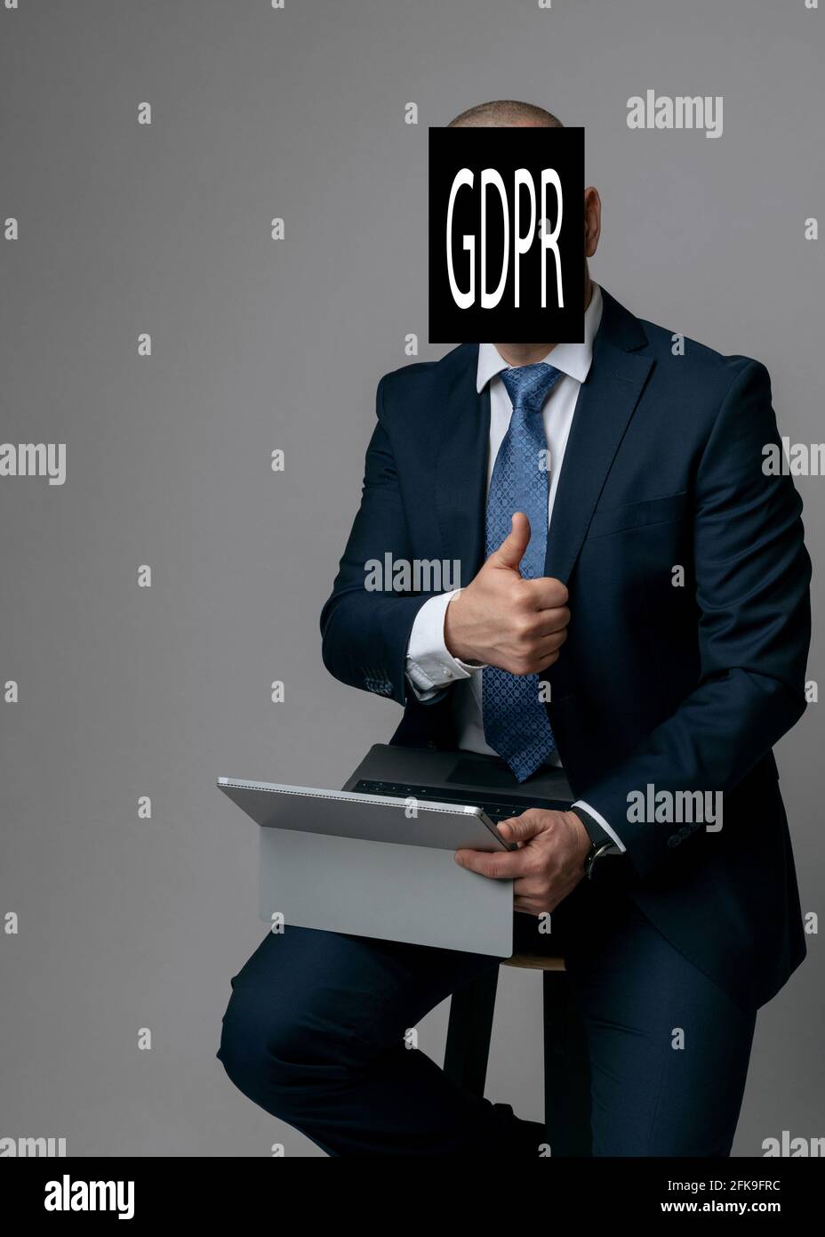 L'uomo d'affari elabora una nota con il titolo della legge sulla protezione dei dati GDPR e tiene un pollice in su. copyspace. Foto Stock